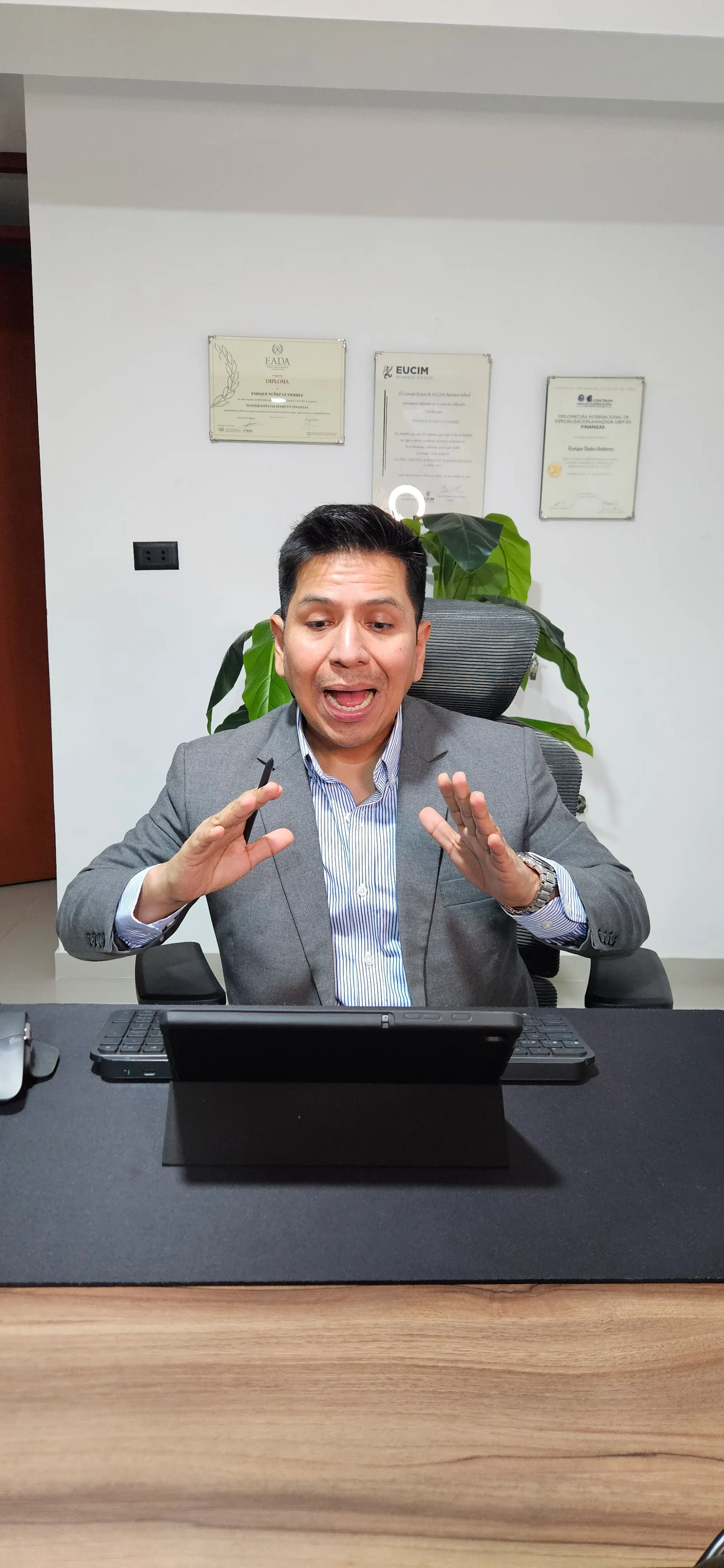 Enrique Núñez en su oficina con diplomas de fondo