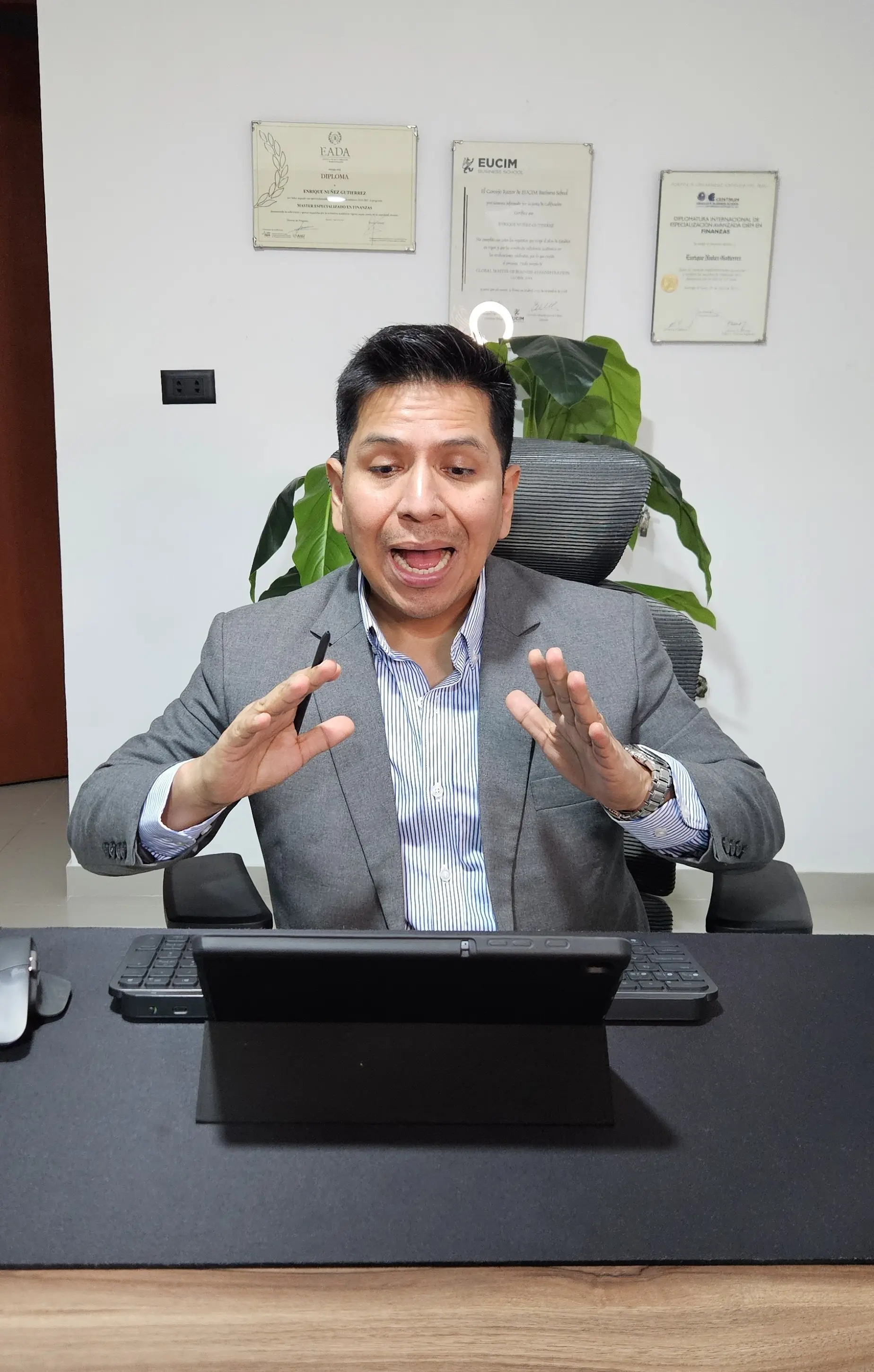 Enrique Nuñez en su oficina con diplomas de fondo